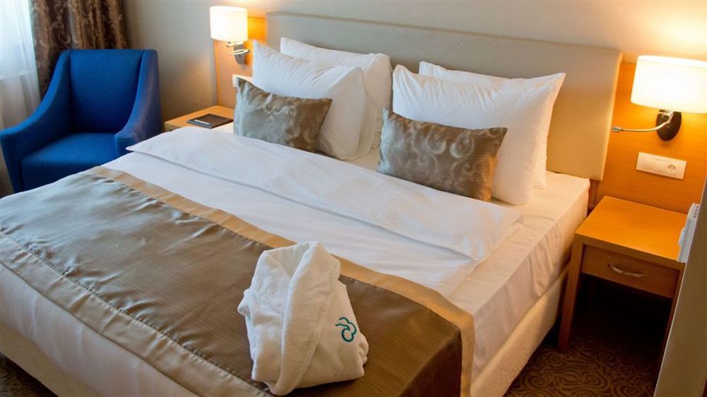 Dedeman Oskemen Tavros Hotel Ustʼ-Kamenogorsk Εξωτερικό φωτογραφία A bed with a duvet cover